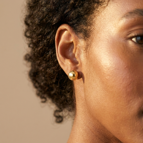 Gold ball stud earrings worn close-up — waterproof by Pippa & Co