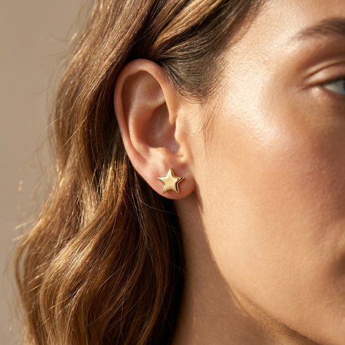 Gold star stud earrings worn close-up — waterproof by Pippa & Co