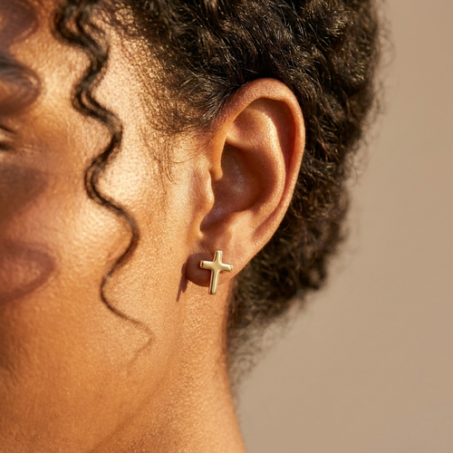 Gold cross stud earrings worn close-up — waterproof by Pippa & Co