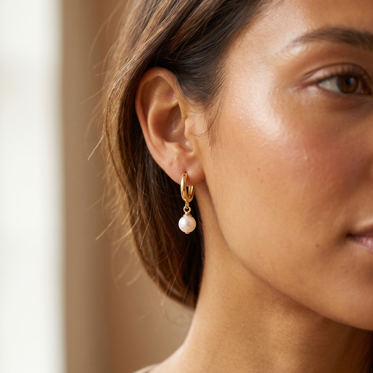 Gold Pearl Huggie Hoops worn close-up