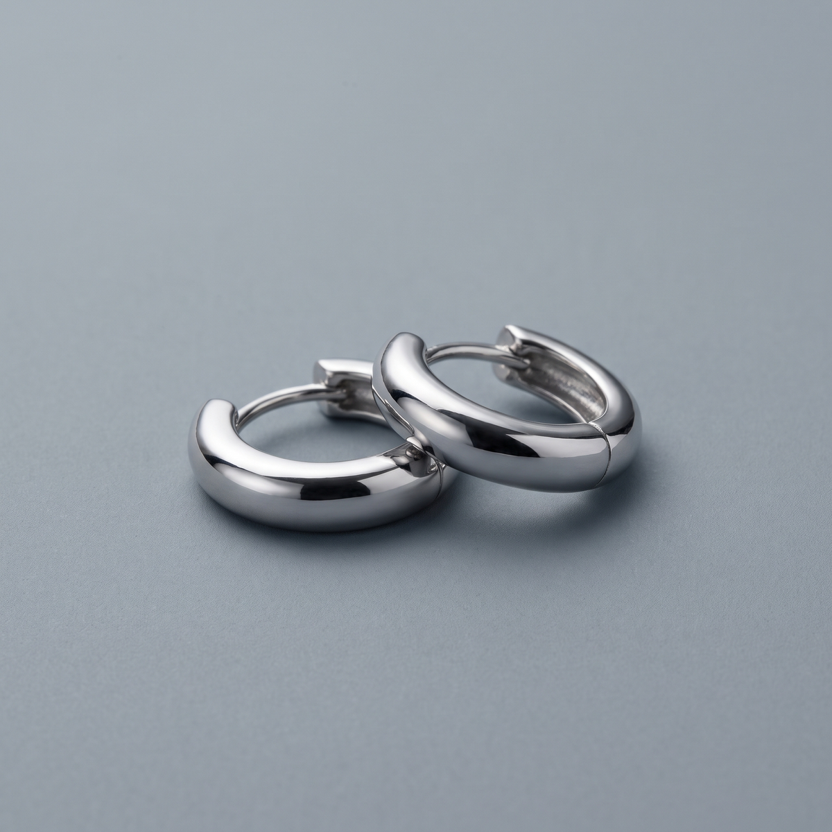 Silver huggie hoops worn close-up