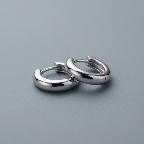 Silver huggie hoops worn close-up
