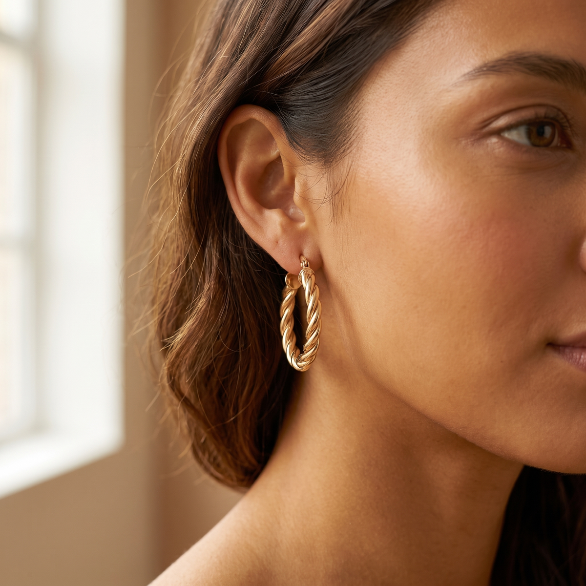 Gold twisted hoop earrings studio product shot